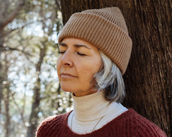 woman with short grey hair and a beanie
