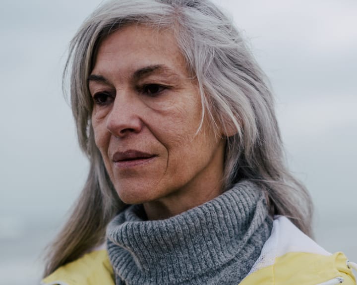 woman with grey hair and grey scarf