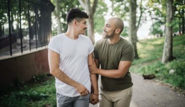gay couple walking in the park holding hands