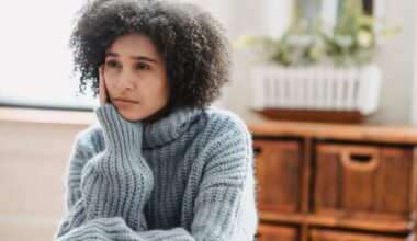 woman in grey sweater sitting looking sad