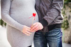 pregnant couple with heart stick