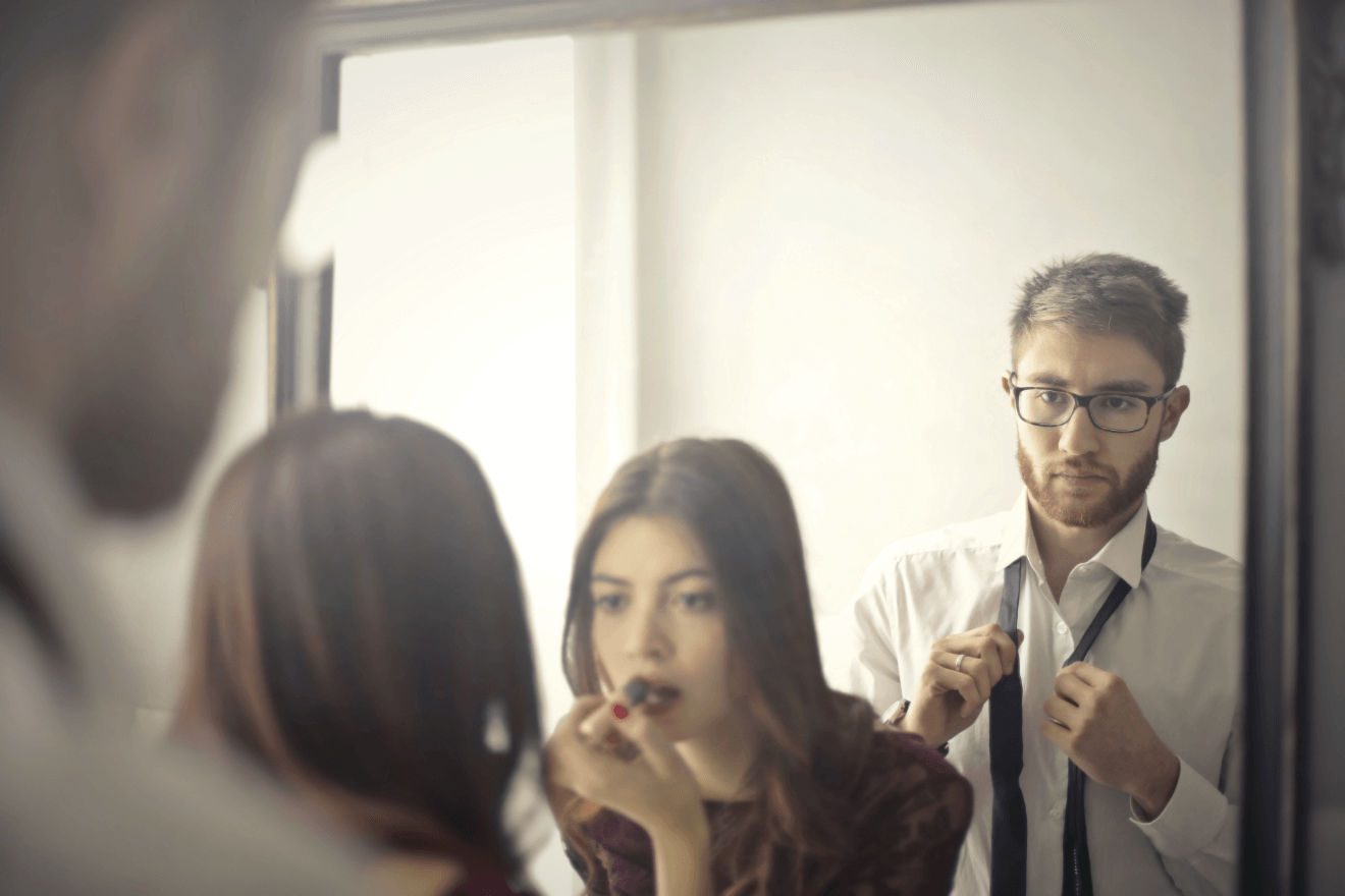 woman putting on lipstick man getting dressed before going out