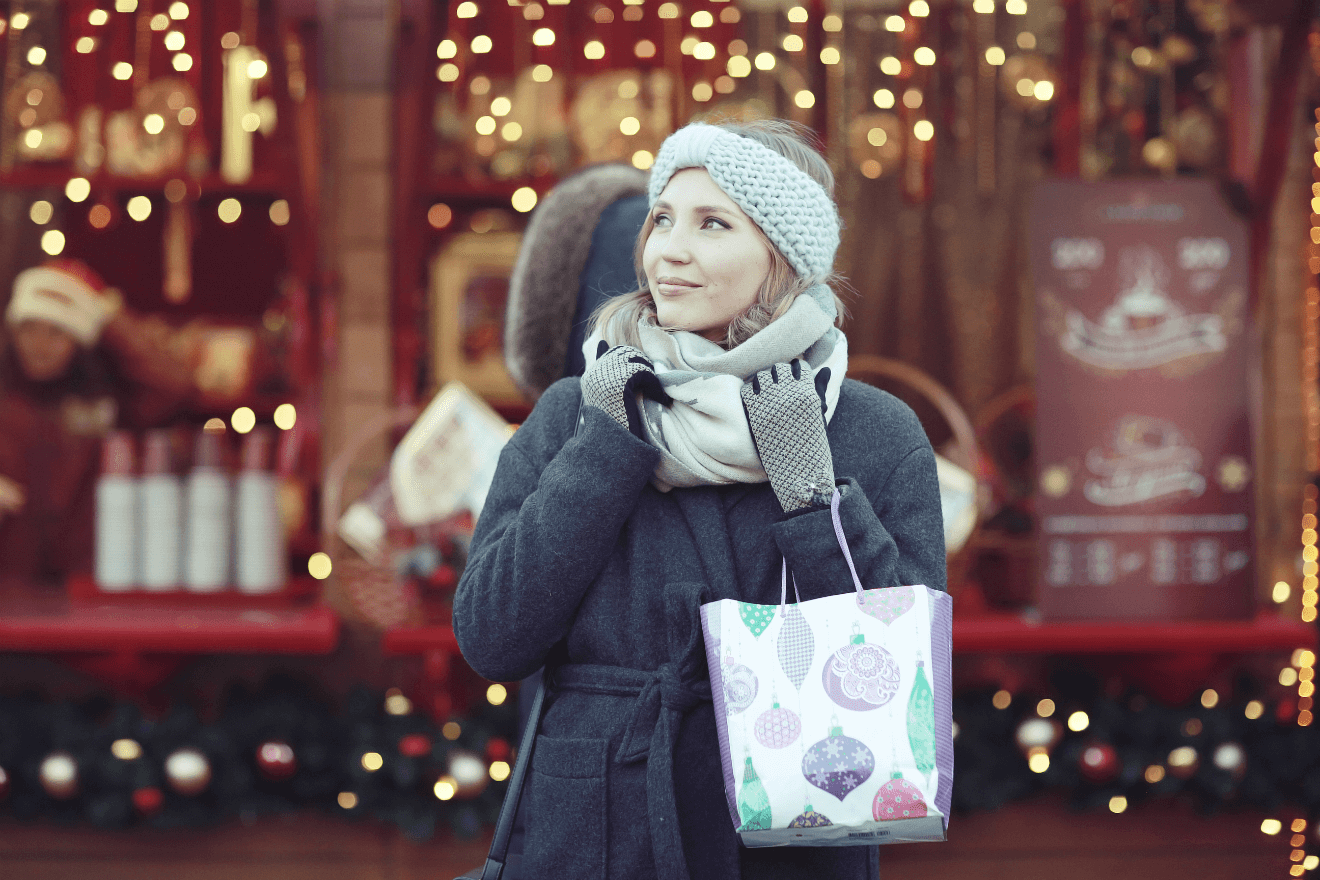 woman outside in coat holiday shopping